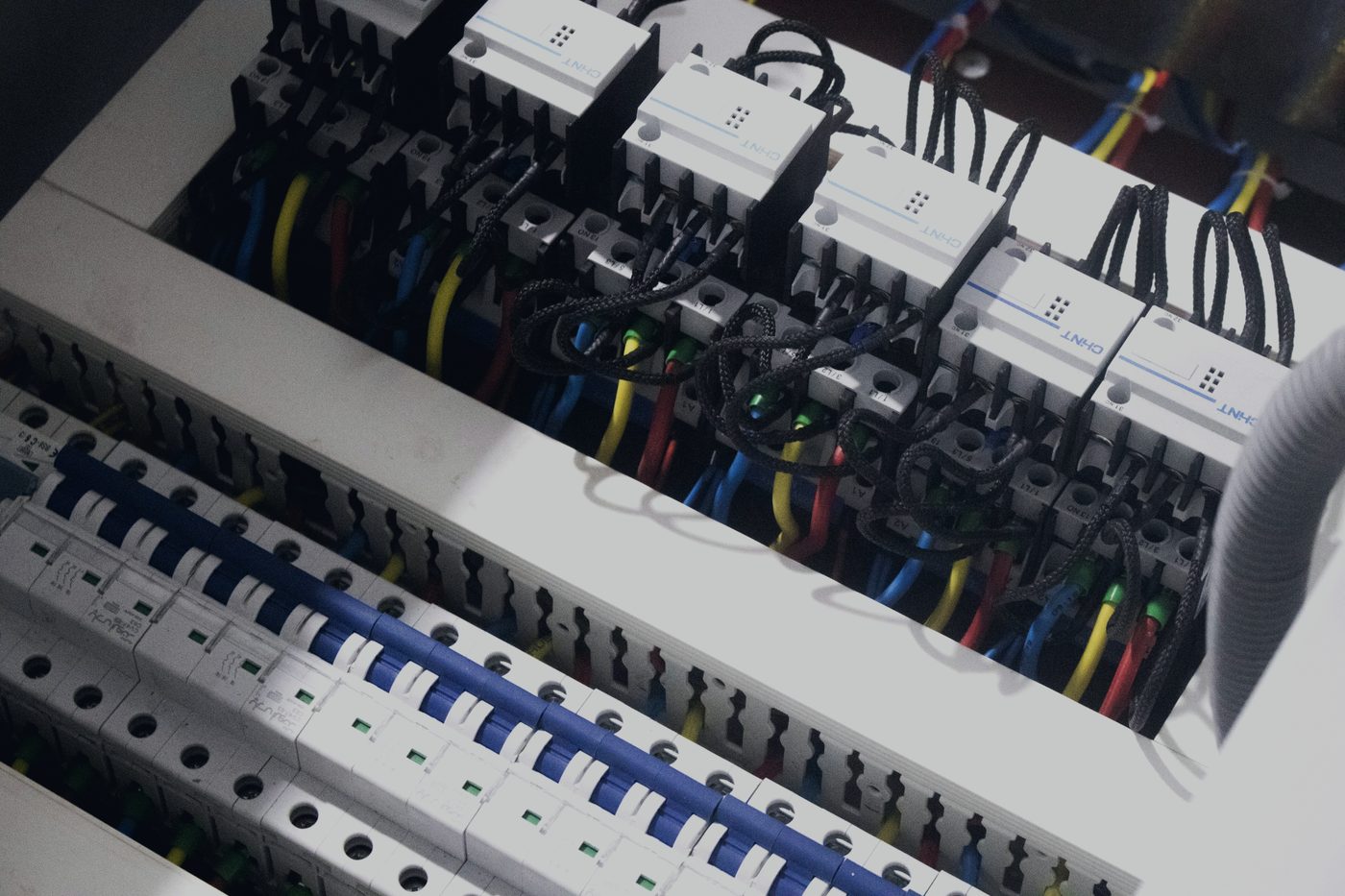 Circuit breakers and neatly terminated blue wiring inside a switchboard