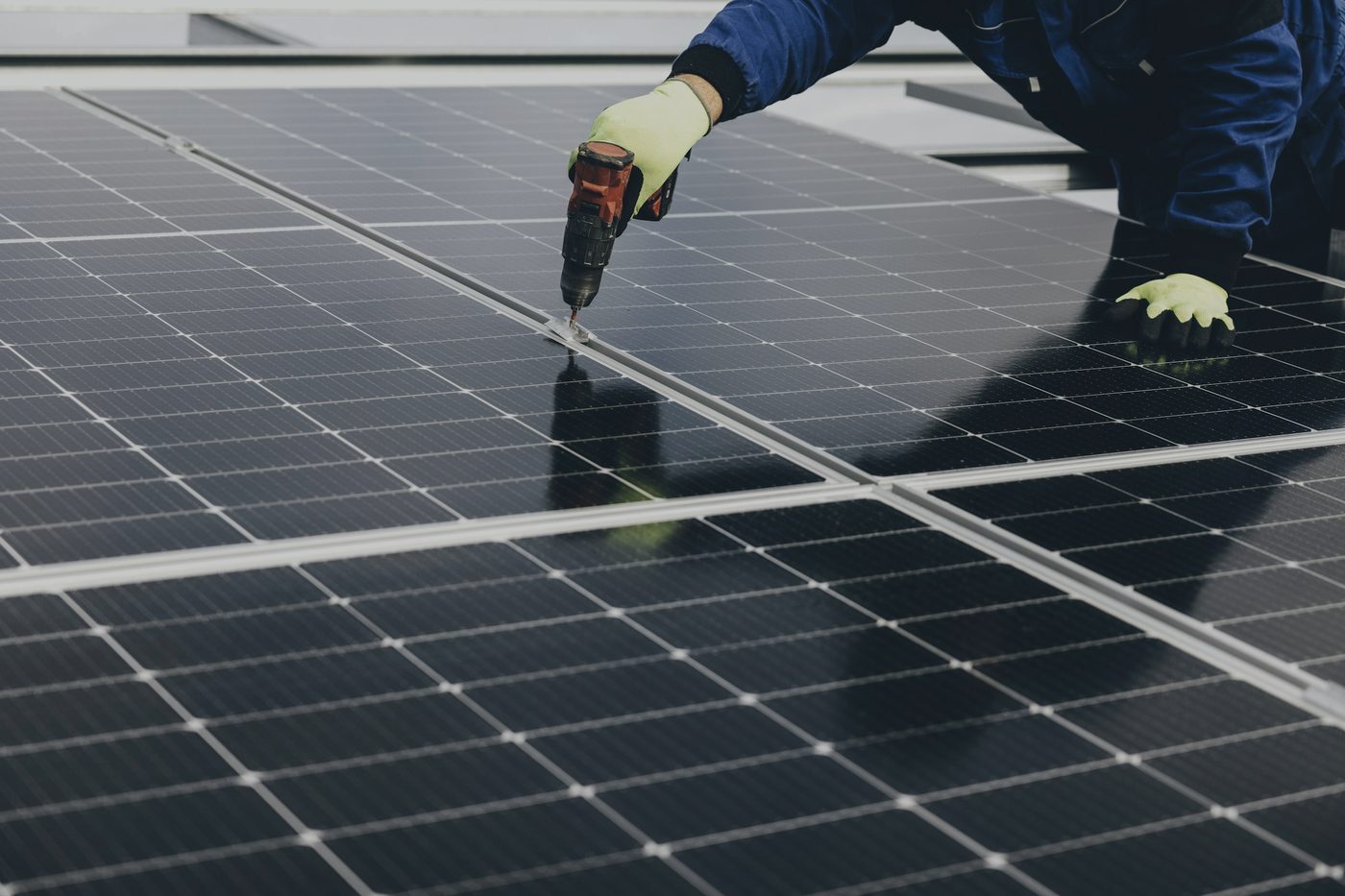 Hands working on a solar panel during installation